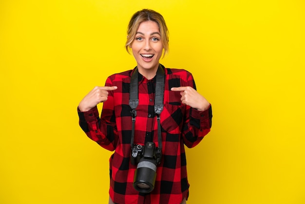 Femme photographe uruguayenne isolée sur fond jaune avec une expression faciale surprise