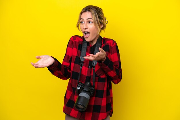 Femme photographe uruguayenne isolée sur fond jaune avec une expression faciale surprise