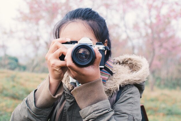 Femme photographiant avec une caméra dans la forêt