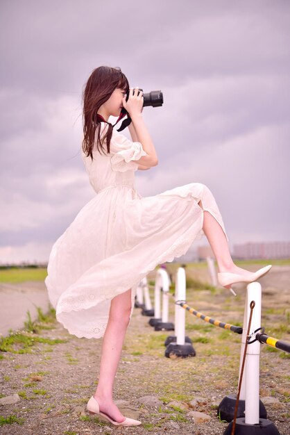 Une femme photographiant contre le ciel