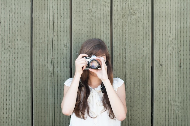 Une femme photographiant contre des planches de bois