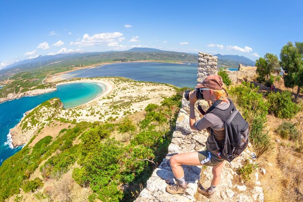 Photo une femme photographiant la mer contre le ciel bleu