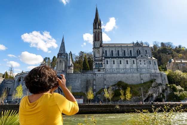 Femme photographie la cathédrale de Lourdes, France