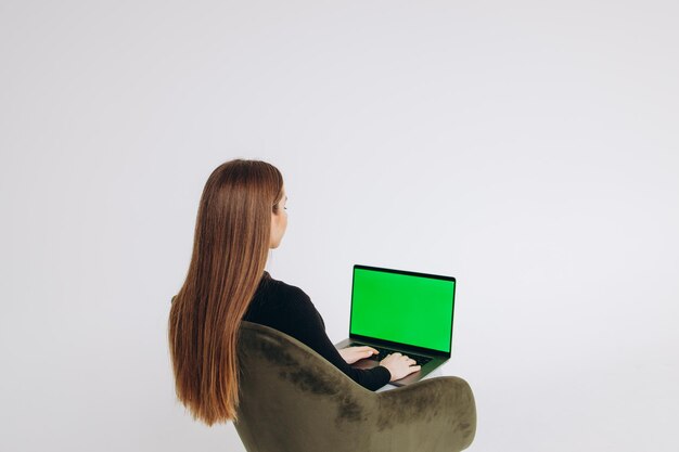 Femme pigiste à l'aide d'un ordinateur portable avec un écran vert sur le moniteur Concept de travail à distance