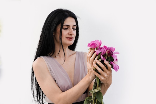 Femme avec pigmentation de la peau vitiligo sur les mains holidng bouquet de fleurs pivoines Maladies saisonnières de la peau