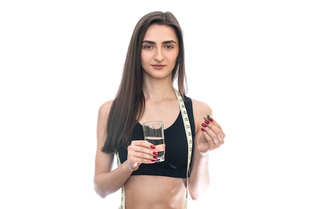 Femme avec des pilules et un verre d'eau isolé sur blanc