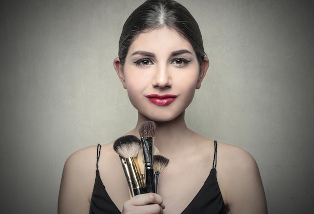 femme avec pinceau de maquillage