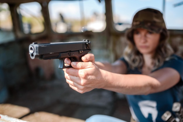 Une femme avec un pistolet à la main apprend à tirer au champ de tir