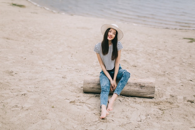 femme sur la plage avec un chapeau