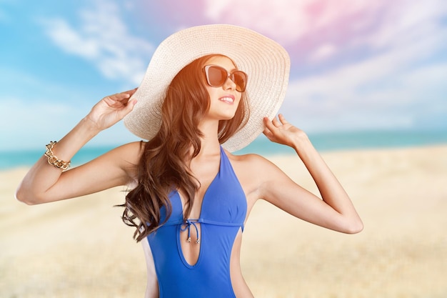 Femme sur la plage en maillot de bain, mode, bronzage, maillots de bain, fille avec un chapeau.