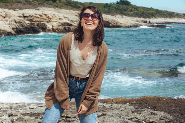 Femme à la plage de la mer profitant de la puissance de la nature venteuse vagues de vacances d'été sur fond