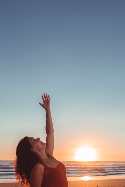 Femme sur la plage pratiquant le yoga