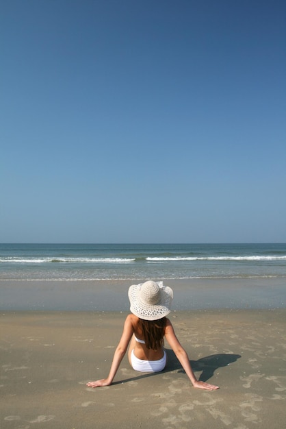 Femme sur la plage près de la mer et du ciel bleu