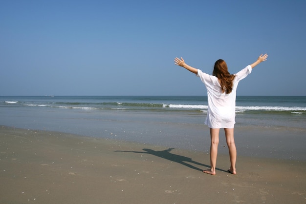 Femme sur la plage près de la mer et du ciel bleu