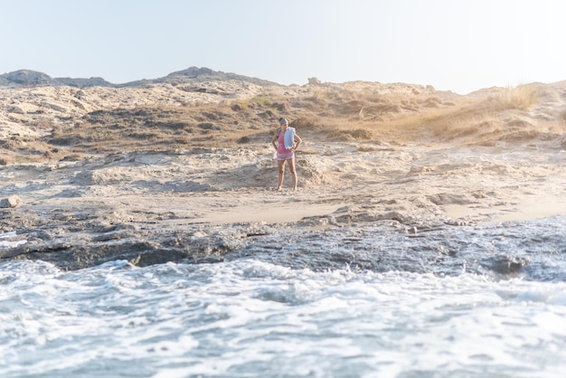 Femme sur la plage de sable près de la mer mousseuse