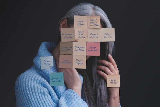 Femme de plan moyen posant avec des notes sur le visage