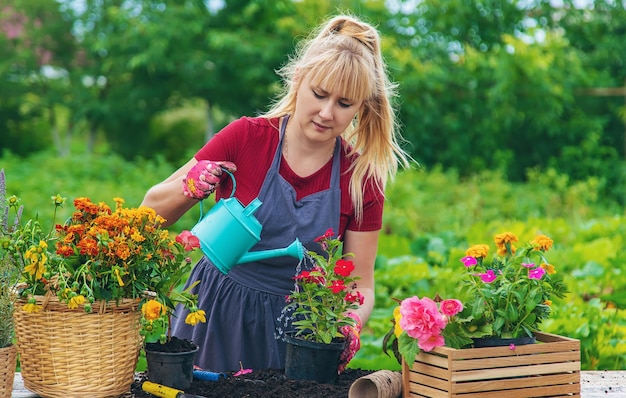 Une femme plante des fleurs dans le jardin Mise au point sélective