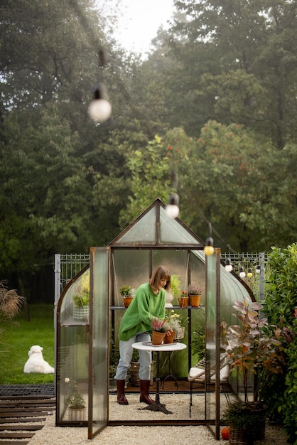 Femme avec des plantes en serre