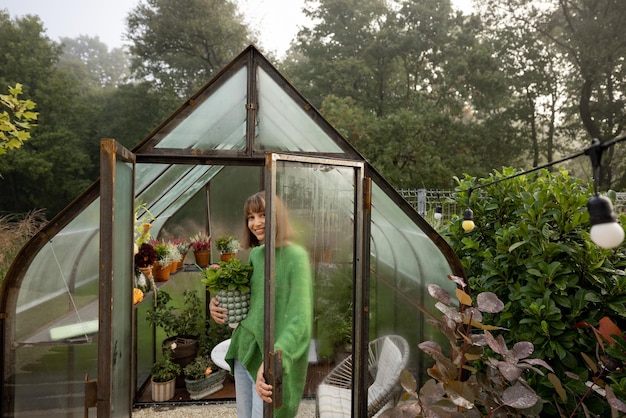 Femme avec des plantes en serre