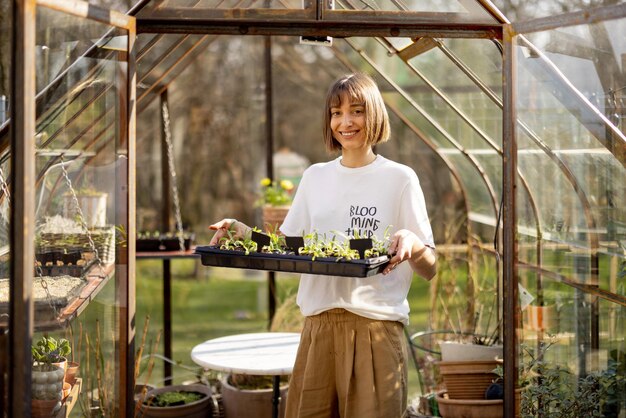 Femme avec un plateau de semis dans le jardin