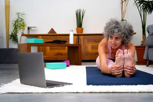 Photo femme plein coup exercice avec ordinateur portable