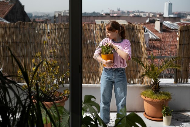 Femme pleine coup tenant un pot de plante