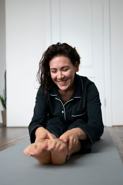 Femme pleine de coups sur un tapis de yoga