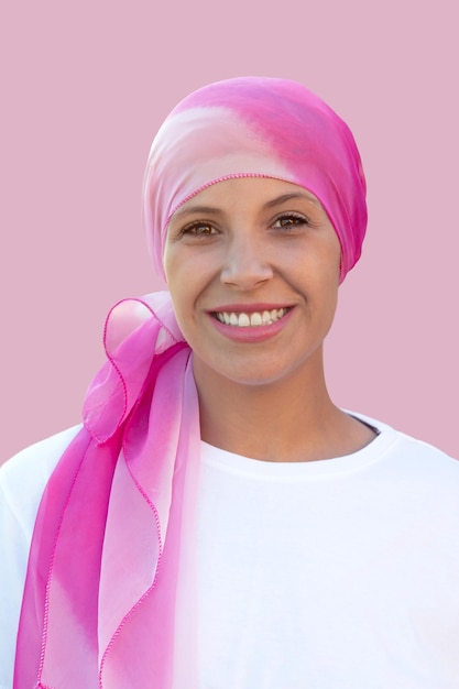 Femme pleine d'espoir portant un foulard sur fond rose
