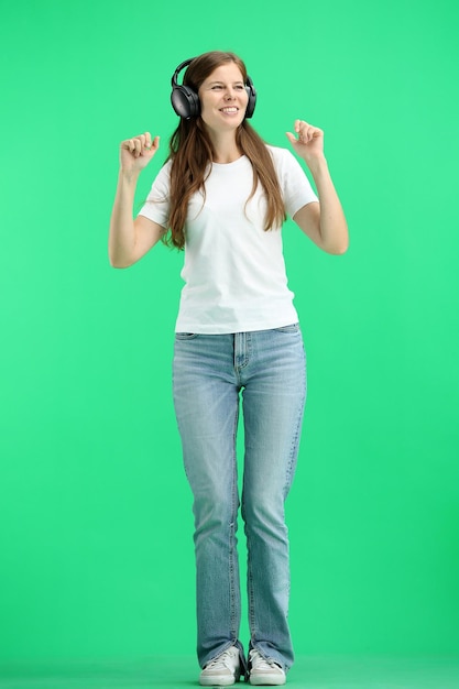 Photo une femme pleine longueur sur un fond vert portant des écouteurs