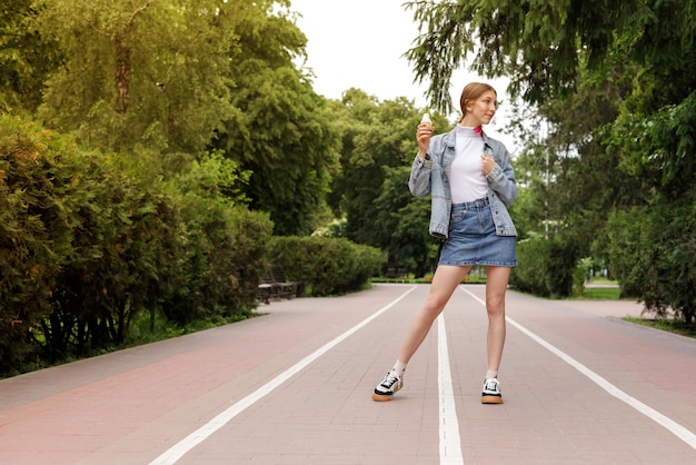 Femme pleine longueur avec de la glace lors d'une promenade