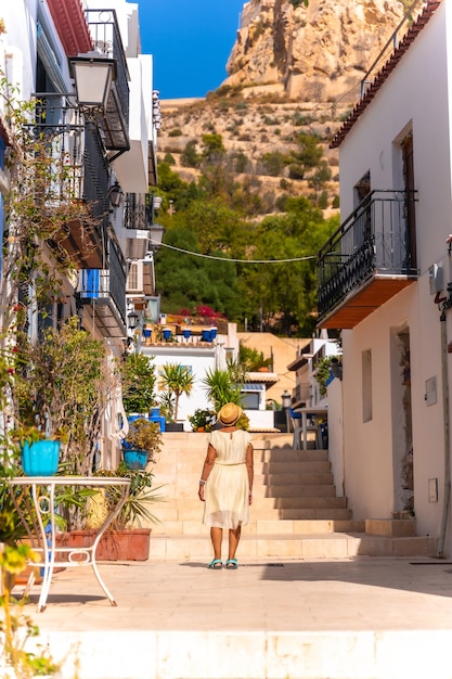 Une femme plus âgée visitant le quartier de Santa Cruz à Alicante Maison méditerranéenne Voyage pour les personnes âgées