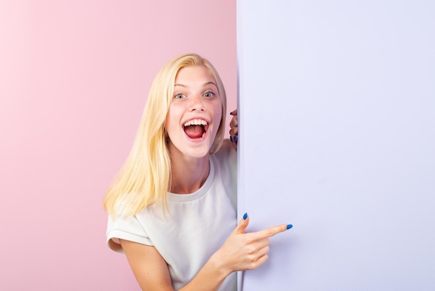 Femme pointant le doigt sur le tableau blanc femme debout derrière la bannière blanche vierge ou copie vide savs