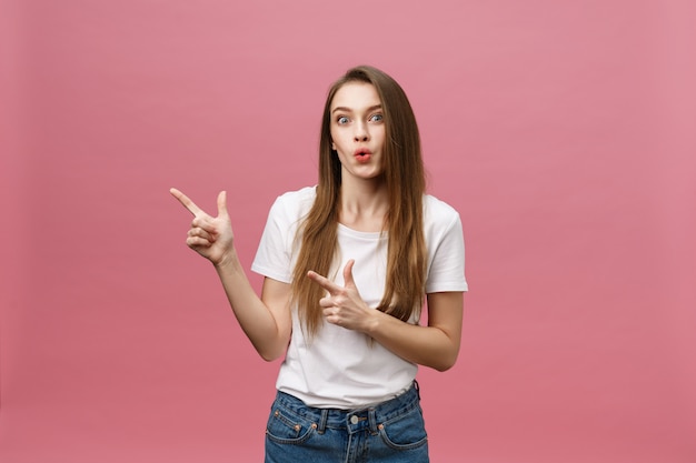 Femme pointant le doigt vers la caméra et souriant aux dents.