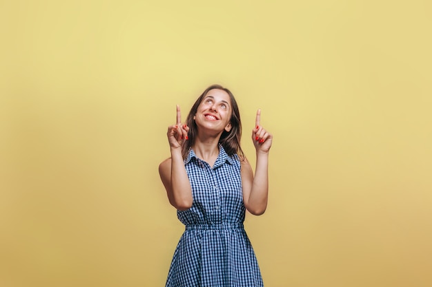 femme pointant le doigt vers le haut. Sur le mur jaune