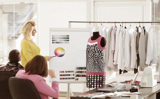 Photo femme pointant sur la palette de couleurs de l'échantillon tout en discutant de la couleur à choisir avec un collègue