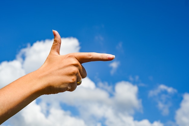 Femme pointant sa main et ciel nuage