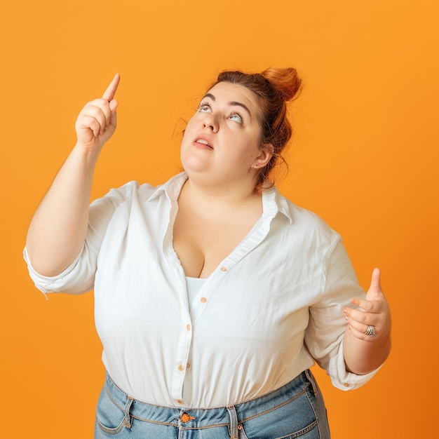 Photo une femme pointant vers quelque chose avec un fond orange