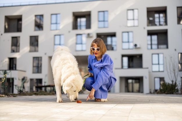 Femme pointe le doigt sur le caca de chien marchant avec un animal de compagnie