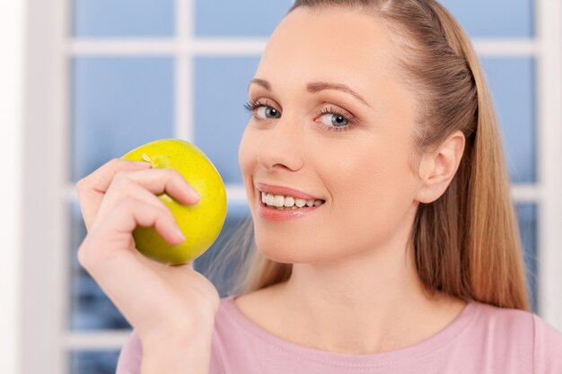 Femme à la pomme. Belle jeune femme mangeant la pomme et te souriant