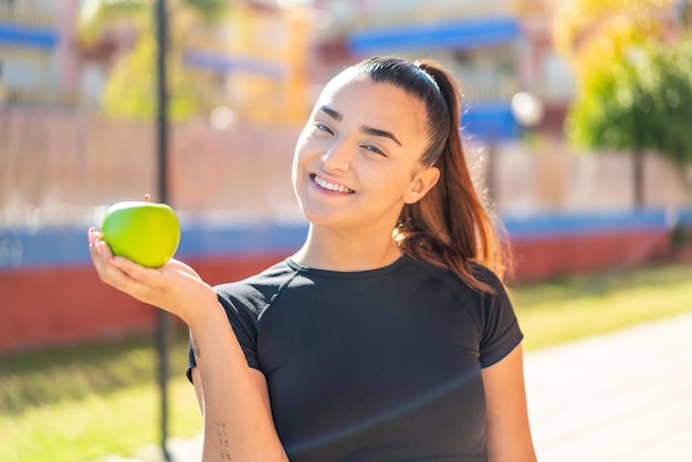 une femme avec une pomme à l'extérieur