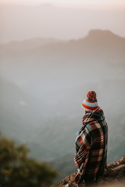 femme avec poncho en regardant les montagnes