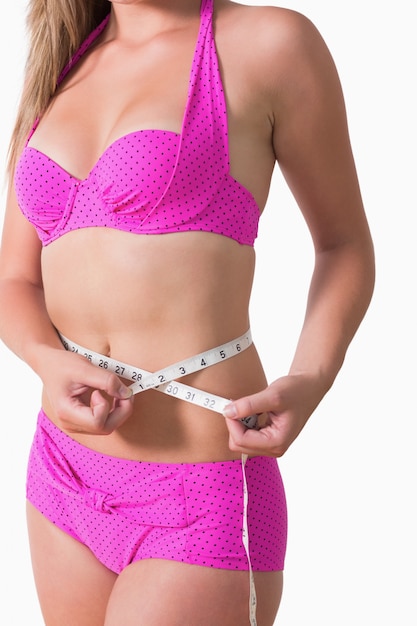 Femme portant un bikini tout en mesurant la taille