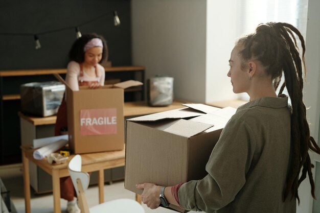 Une femme portant une boîte en carton emballée