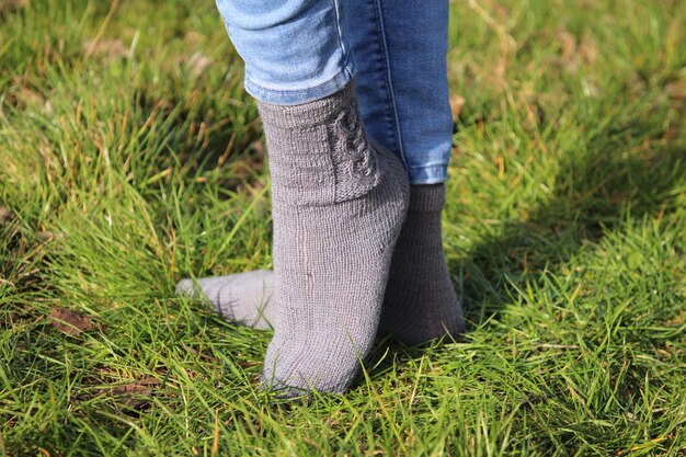 Photo une femme portant des bottes grises se tient dans l'herbe