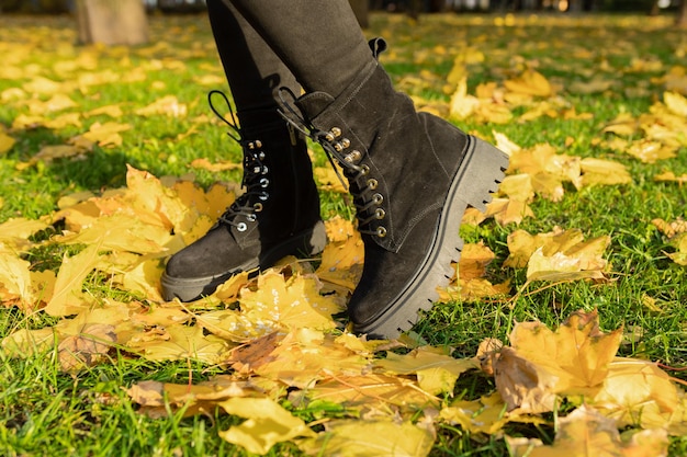 Une femme portant des bottes noires avec le mot automne en bas.