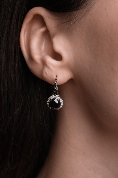 une femme portant une boucle d'oreille avec un diamant et une boucled'oreille en diamant