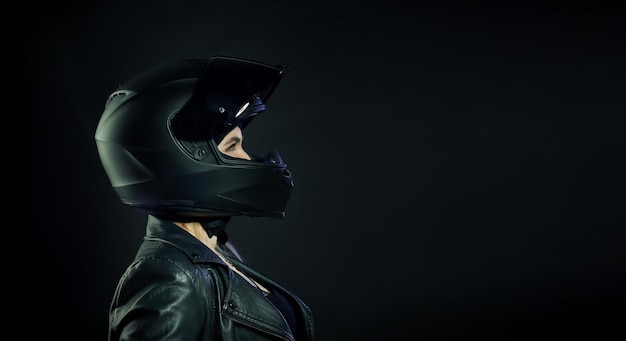 Une femme portant un casque de moto sur un fond sombre Le concept d'espace