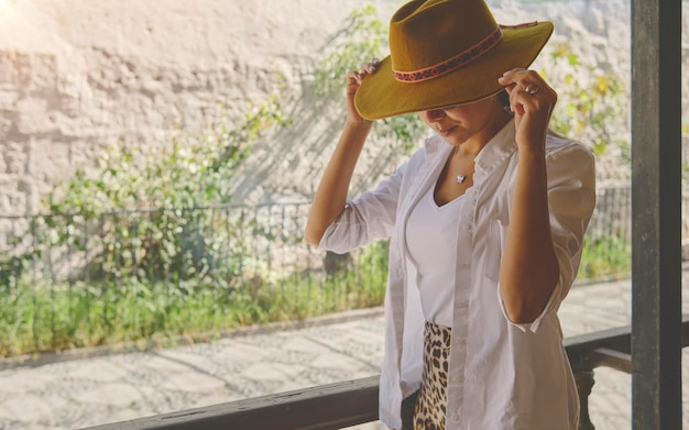 Femme portant un chapeau de cow-boy assise sur le porche Jalisco Mexique portrait d'une femme heureuse utilisant un chapeau