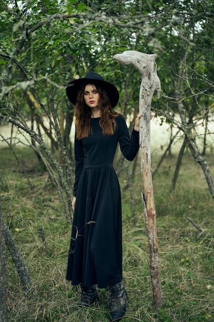 Photo femme portant un chapeau debout contre les arbres