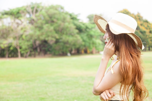 Femme portant un chapeau, parler au téléphone.